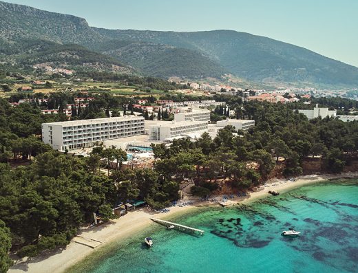 Aerijalni pogled na Bluesun hotel Elaphusa okružen borovom šumom sa plažom, tirkiznim morem i planinama u pozadini