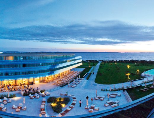 Eksterijer Falkensteiner Hotel & Spa ladera sa terasom, ležaljkama za sunčanje, zelenim travnjakom i pogledom na more u sumrak