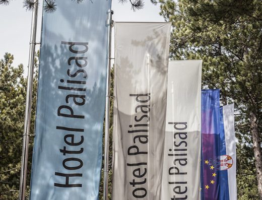 Zastave Hotel Palisad sa natpisima Relax, Leisure i Congress meÄ‘u borovim drveÄ‡em