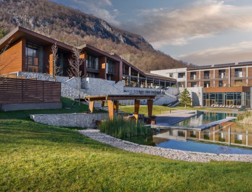 Pogled na kompleks Hotel Ramonda sa modernim zgradama, dekorativnim jezerom i planinom u pozadini