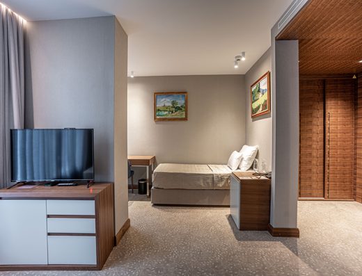 Apartman u Hotel Tonanti sa dnevnim delom, TV-om na komodi, krevetom u odvojenom delu, drvenim plafonom i uljnim slikama