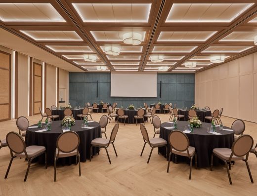 Balska dvorana u Hyatt Regency Kotor Bay Resort sa okruglim stolovima u banket rasporedu, tamnim stolnjacima, cvećem i drvenim kasetiranim plafonom