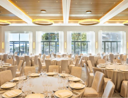 Banket sala u Hyatt Regency Zadar sa svečano postavljenim okruglim stolovima, bež navlakama za stolice, kružnim lusterima i velikim prozorima sa pogledom na zelenilo