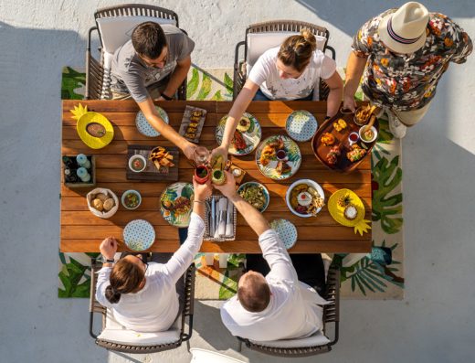 Grupalna večera u Key West Beach & Restaurant sa šarenim tanjirima, tropskim podmetačima i nazdravljanjem