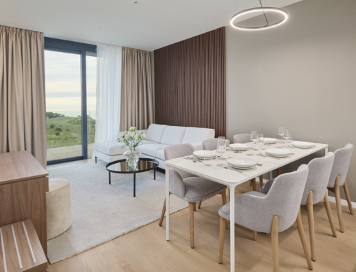 Apartman u Petram Resort & Residences sa dnevnom sobom, trpezarijskim stolom, drvenim panelima i pogledom kroz panoramski prozor