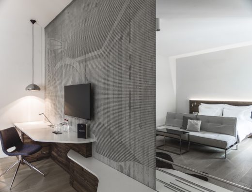 Apartman u hotelu Radisson Collection Hotel Old Mill Belgrade sa betonskom teksturalnom pregradom, televizorom, radnim stolom, krevetom i kaučem u loft stilu